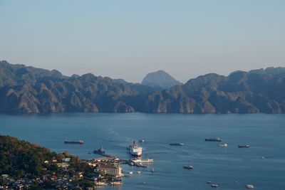 Scenic view of sea and mountains against clear sky