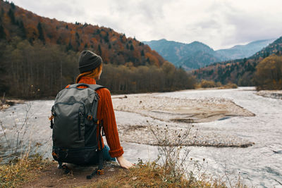 Rear view of man sitting on mountain road