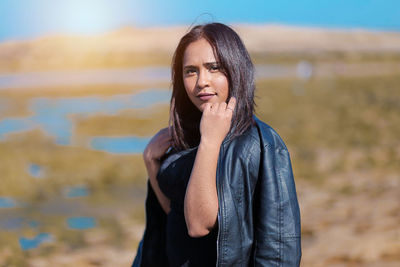 Portrait of woman standing against blurred background