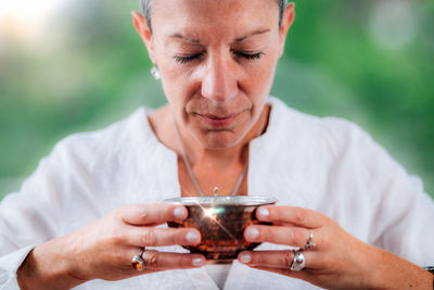 Spiritually awaken woman practicing mindfulness, infusing intention into her morning tea