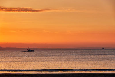 Scenic view of sea against orange sky during sunrise