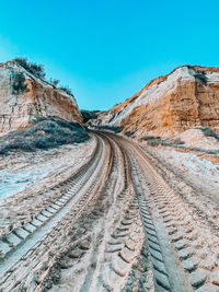 Panoramic view of road amidst mountains against clear blue sky