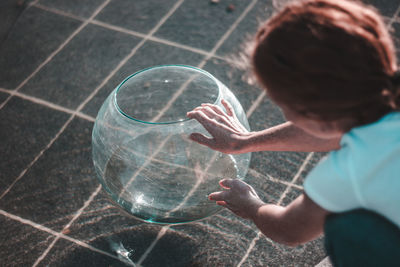 Close-up of woman holding glass container at fountain