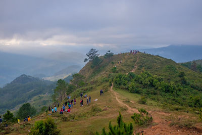 People on mountain against sky