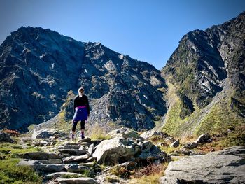 Rear view of man on rocks against mountains