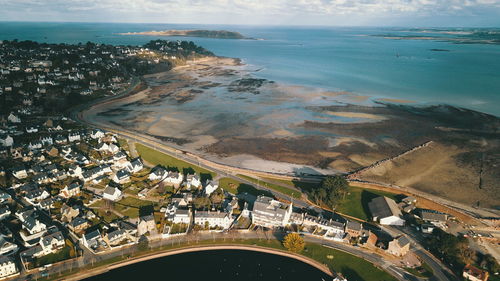 High angle view of road by sea and buildings against sky