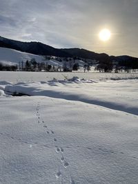 Scenic view of snow covered field against sky