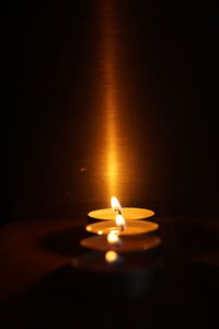 Close-up of burning candle on table