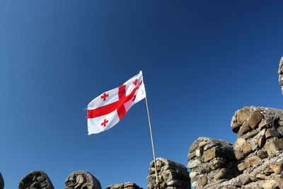 Low angle view of flag against blue sky