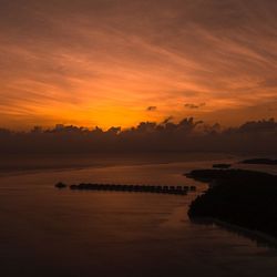 Scenic view of lake against orange sky