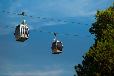 Low angle view of overhead cable cars against sky