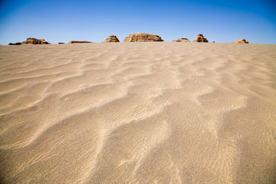 Low angle view of sand dune against clear sky