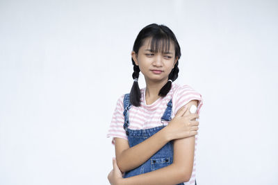 Portrait of girl standing against white background