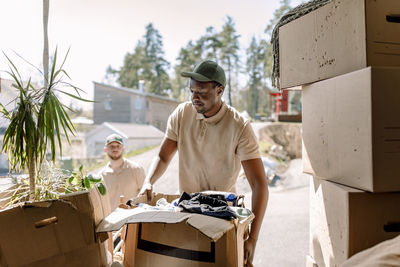 Movers picking cardboard boxes from delivery truck
