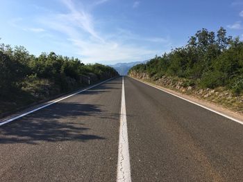 Road amidst trees against sky