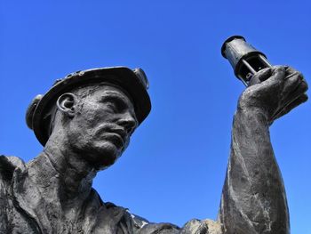 Low angle view of statue against clear blue sky