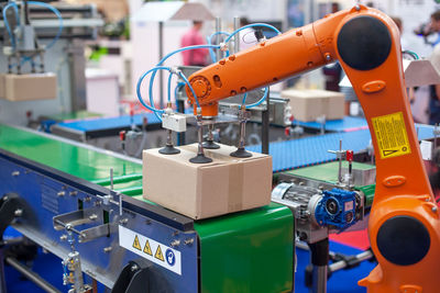 Robotic or robot arm in automated factory packing system for efficient industrial box handling