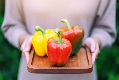 Close-up of woman holding red bell peppers