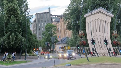 People on street amidst trees and buildings in city