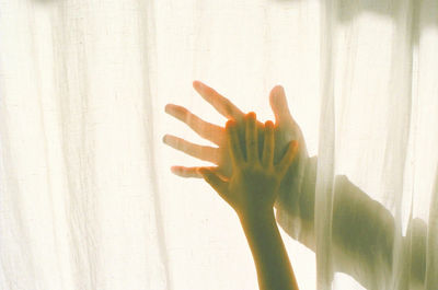 Close-up of hand touching window