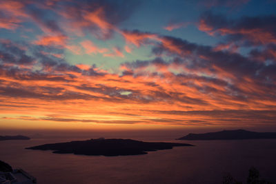 Scenic view of sea against dramatic sky during sunset