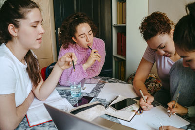 Female friends studying together while doing homework