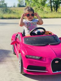 Youth riding in her pink bugatti