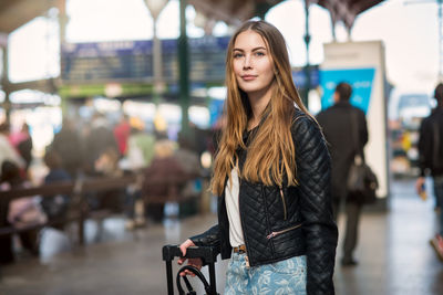 Portrait of beautiful woman standing with umbrella