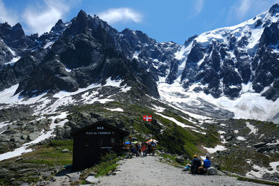 People on snowcapped mountain against sky