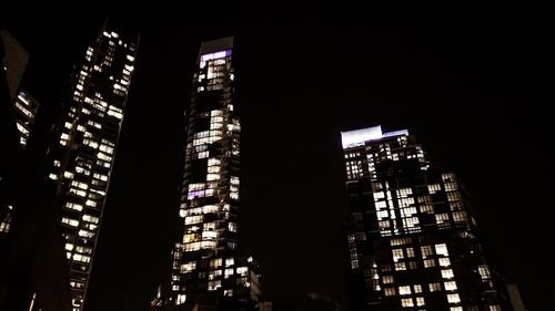 Low angle view of illuminated buildings against sky at night