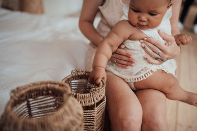 Midsection of cute baby girl on bed at home