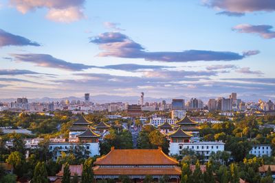 Buildings in city against cloudy sky