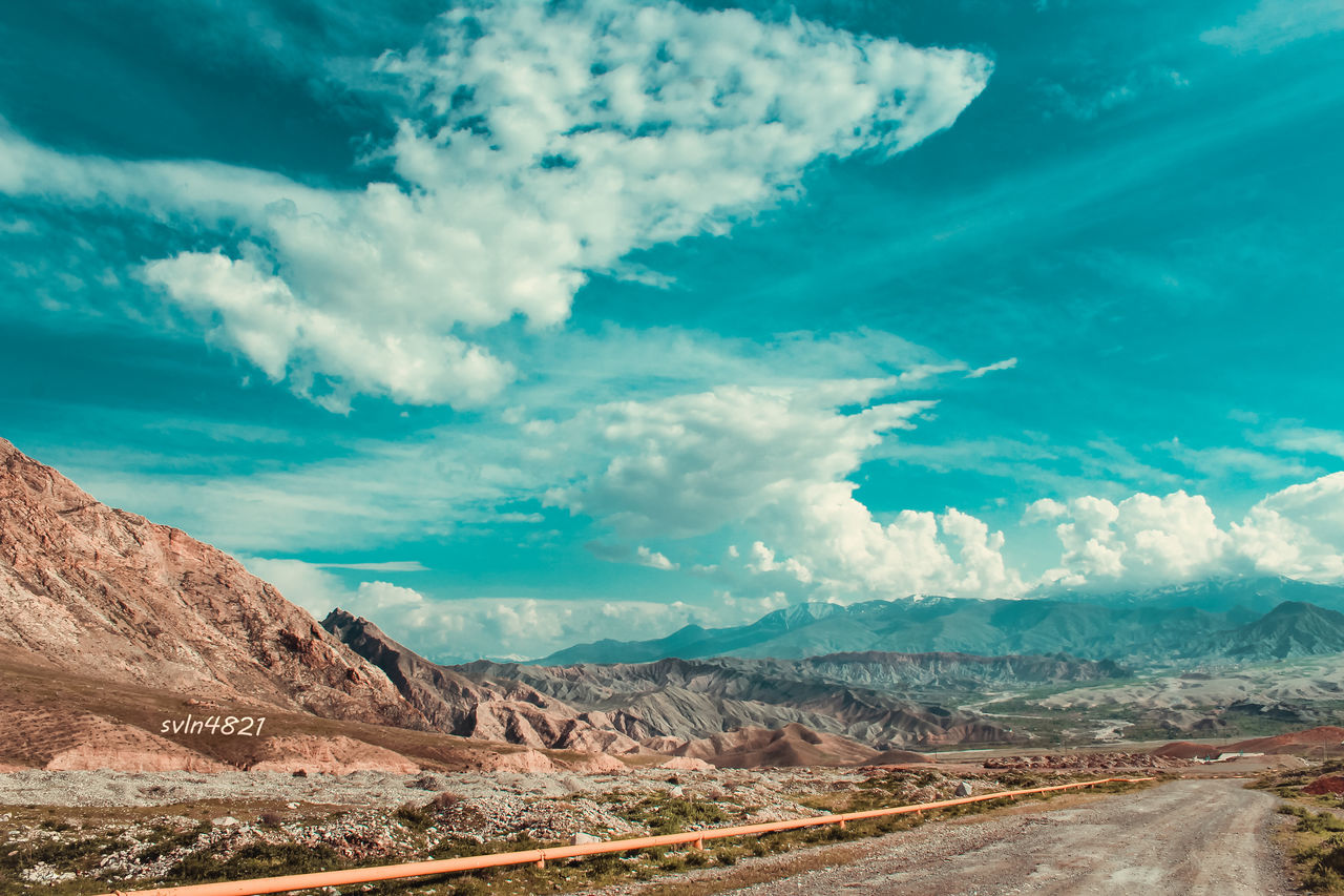 sky, landscape, tranquil scene, mountain, road, tranquility, transportation, scenics, cloud - sky, blue, nature, beauty in nature, the way forward, cloud, non-urban scene, horizon over land, remote, country road, mountain range, cloudy