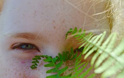 Close-up portrait of girl and plant