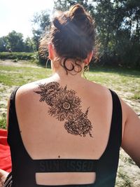 Rear view of teenage girl with henna tattoo on back