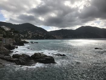 Scenic view of sea and mountains against sky