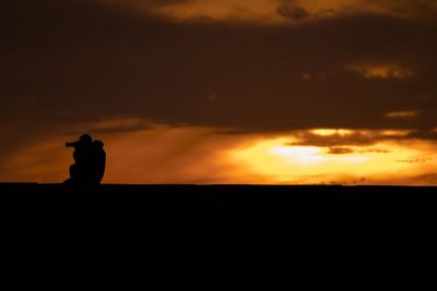 Silhouette of trees against dramatic sky