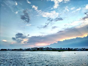Scenic view of river against cloudy sky
