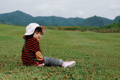 Smiling baby girl sitting on grassy field