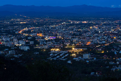 High angle view of illuminated city against sky at night