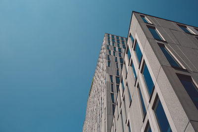 Low angle view of modern building against clear blue sky