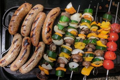 Chicken sausages and vegetable kebabs on the grill 