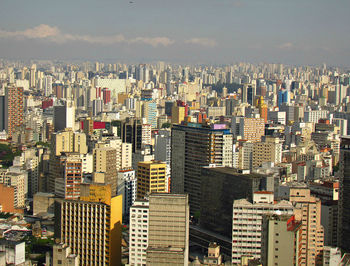 Aerial view of buildings in city against sky