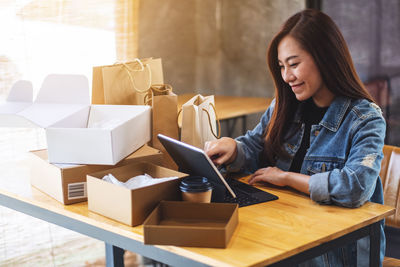 Young woman using laptop while sitting on table