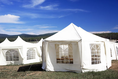 White tent on field against sky