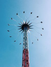 Low angle view of chain swing ride against clear blue sky