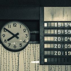 Low angle view of clock and arrival departure board at railroad station