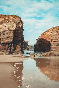 Rock formations in sea against sky