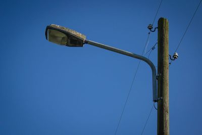 Low angle view of power lines against clear blue sky