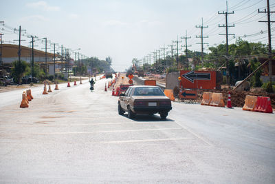 Cars on road against sky in city